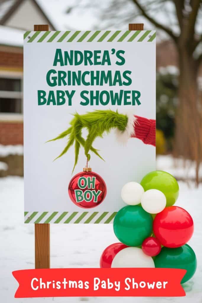 Christmas baby shower sign with Grinch hand holding a red ornament reading “Oh Boy,” decorated with red, green, and white balloons. Perfect inspiration for Christmas baby shower ideas and holiday baby shower themes.