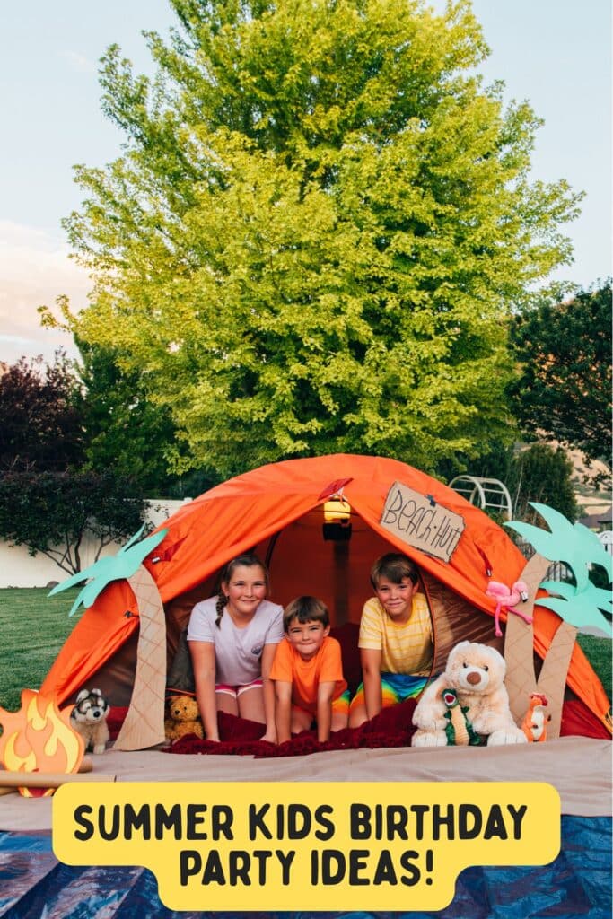  Three kids playing inside a decorated orange tent labeled “Beach Hut” at a backyard summer birthday party. Creative beach-themed party setup for children.