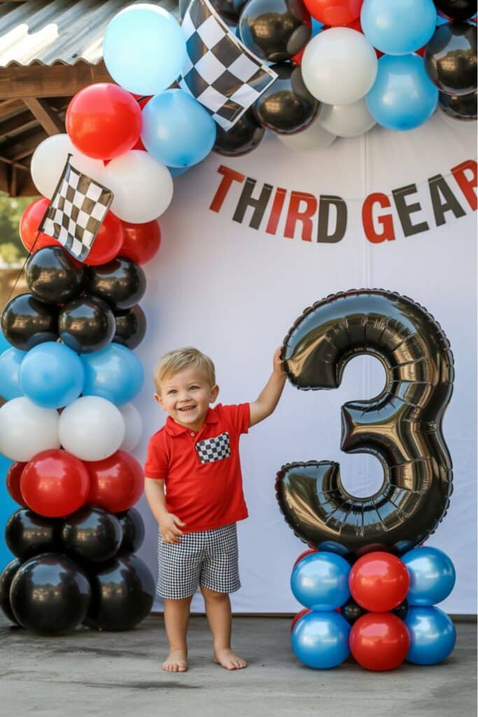 Farm themed 3rd birthday party setup with cow print balloons, a red barn backdrop, and a giant gold number 3 balloon.