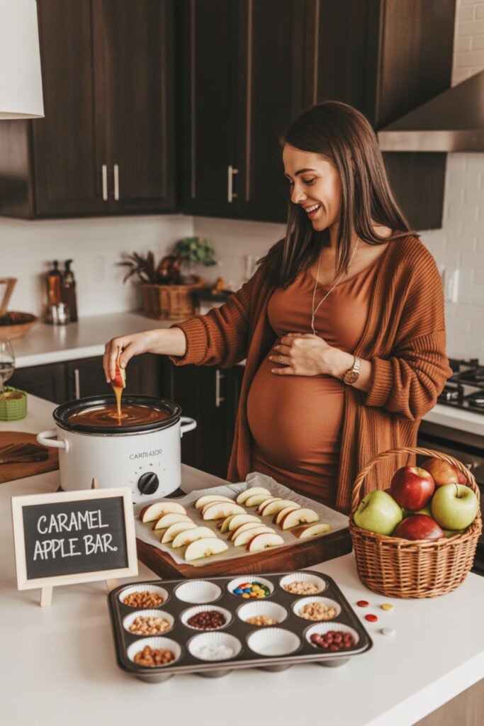 Pregnant woman at fall baby shower dipping apples in caramel at caramel apple bar with toppings — apple of my eye baby shower food station idea.