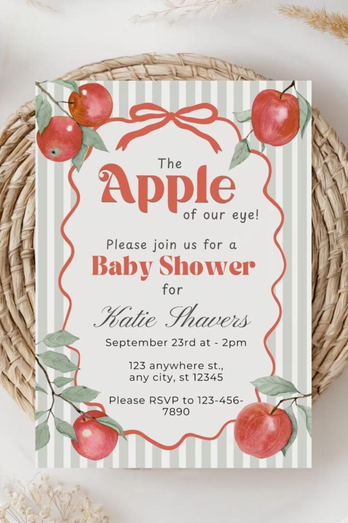 Apple of Our Eye baby shower invitation with red apples, green striped background, and modern script — perfect for a fall baby shower theme.