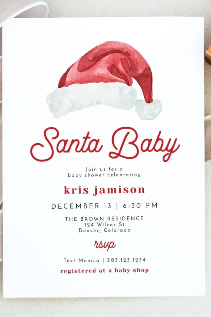 Santa Baby baby shower invitation with watercolor Santa hat illustration and red script lettering, featuring event details in modern typography — a festive and stylish Christmas baby shower invite design.