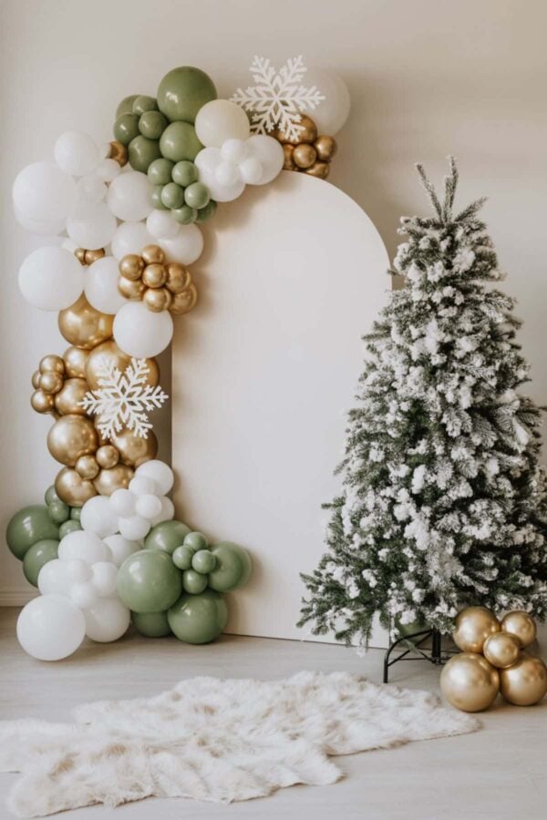 Collage of winter woodland baby shower ideas featuring a snowy pine tree and balloon arch in green, white, and gold; a woodland animal cake with fox, raccoon, and bear decorations; themed sugar cookies shaped like foxes, deer, and "oh baby" wreaths; and a teddy bear setup with brown, cream, and green balloons and a baby shower sign.