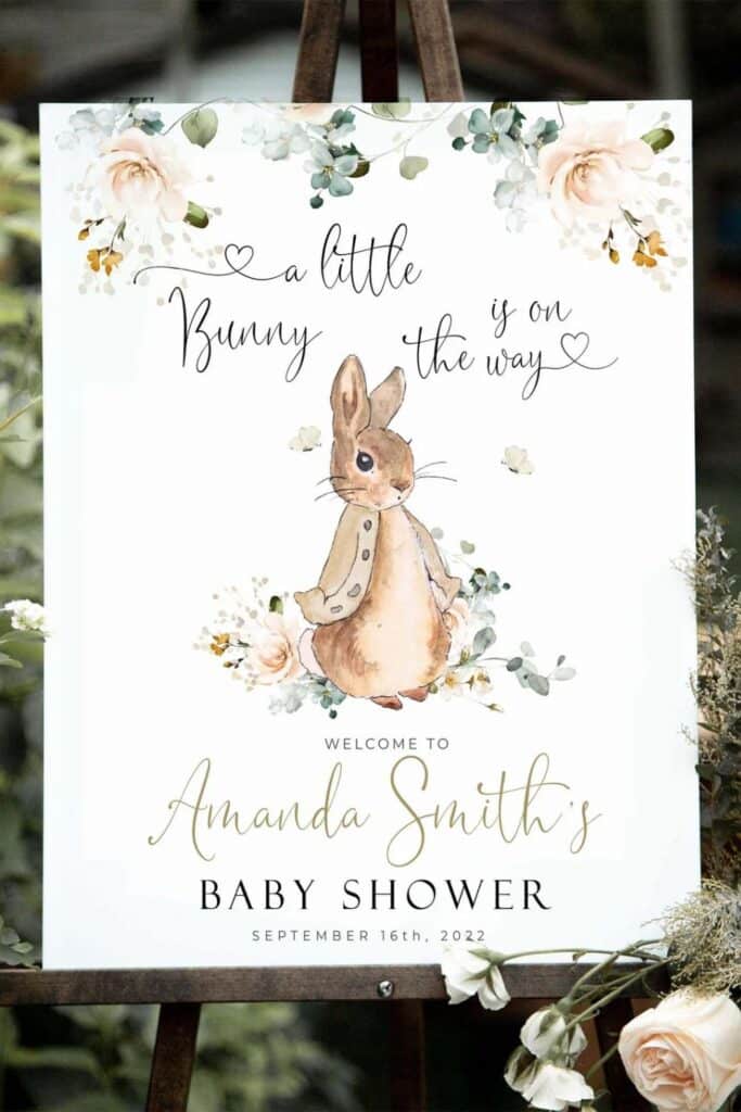 A little bunny is on the way’ watercolor welcome sign with florals and a cute rabbit illustration at a spring baby shower.