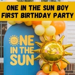 One in the Sun boy first birthday party decor featuring a sunshine backdrop, gold sun balloon, and yellow and orange balloon garland, perfect for a summer first birthday party, outdoor birthday celebration, and first birthday theme ideas for boys