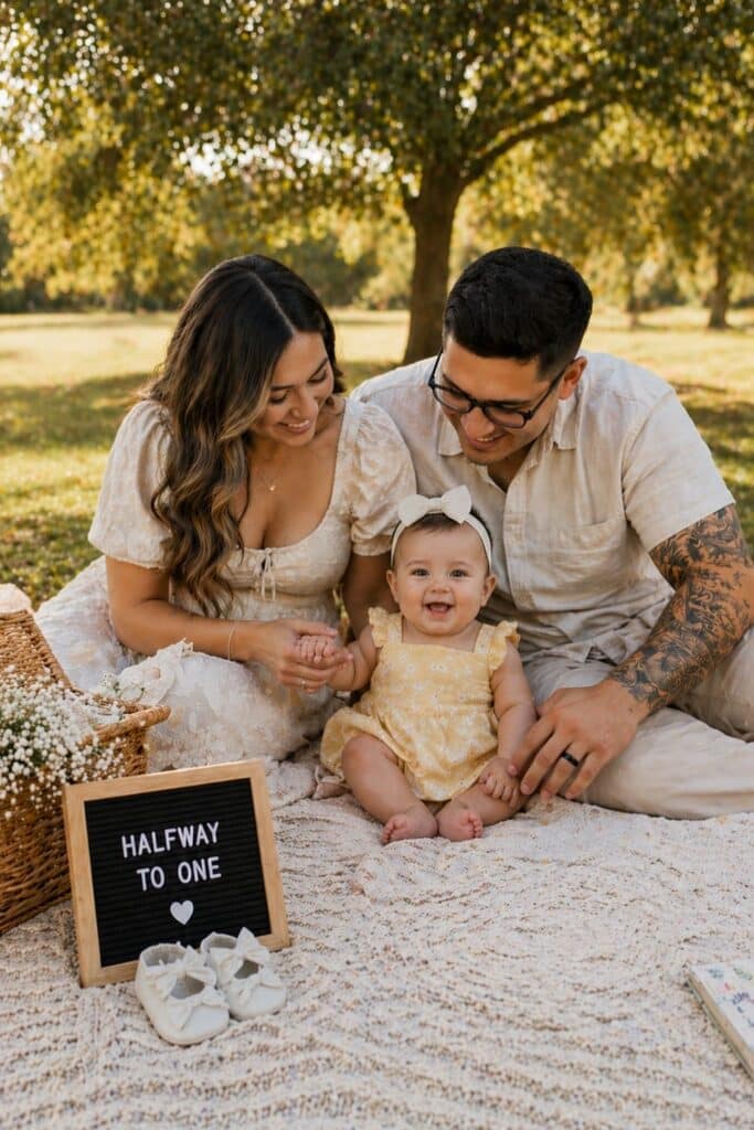 Outdoor family picnic half birthday photo idea with baby girl, halfway to one milestone pictures, cozy neutral 6 month family photoshoot inspiration